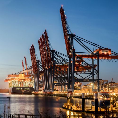 container terminal cranes loading ship dusk